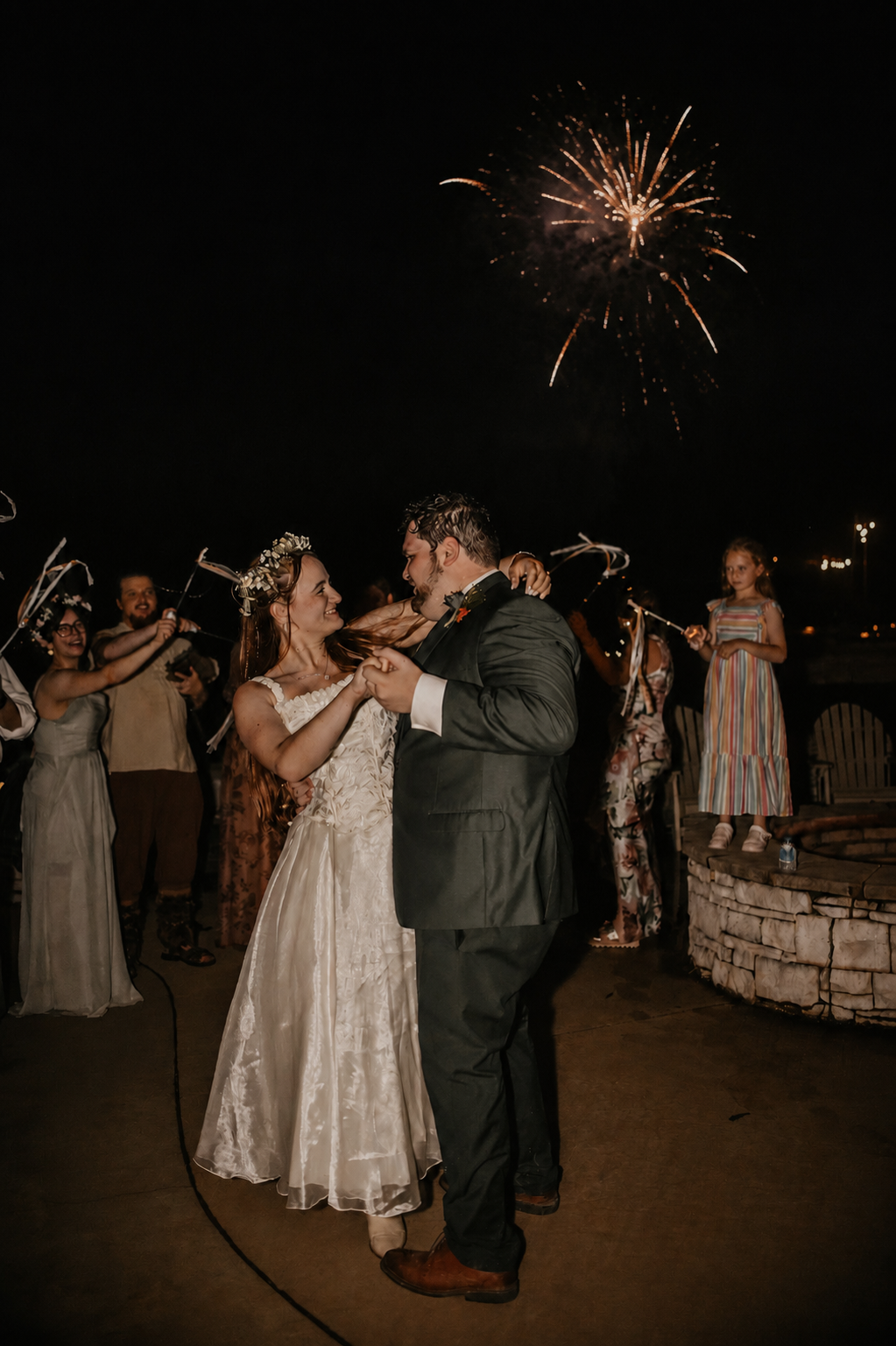 Bride and groom dancing under fireworks at the end of the reception
